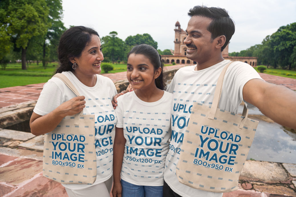 Selfie Mockup Featuring a Happy Family Wearing T-Shirts and Carrying Tote Bags