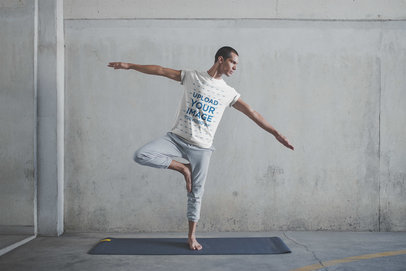 Man Balancing Wearing a T-Shirt Mockup at the Yoga Class