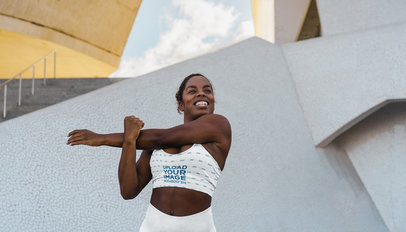 Sports Bra Mockup Featuring a Happy Woman Stretching Her Arm