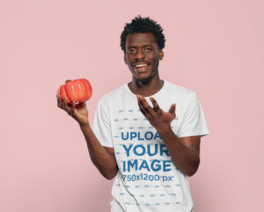 T-Shirt Mockup Featuring a Happy Man With Afro Hair Holding a Pumpkin