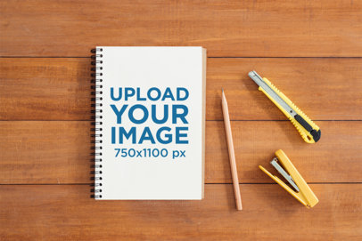 Mockup of a Notebook Placed Over a Wooden Surface Featuring a Pencil and Some School Utensils m28762 r-el2