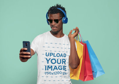 T-Shirt Mockup of a Man with Sunglasses and Shopping Bags Taking a Selfie