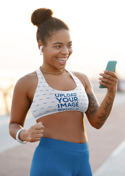 Sports Bra Mockup of a Happy Woman Using Her Smartphone