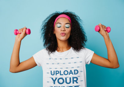 Tee Mockup of a Woman with Small Dumbbells Blowing a Kiss at the Camera