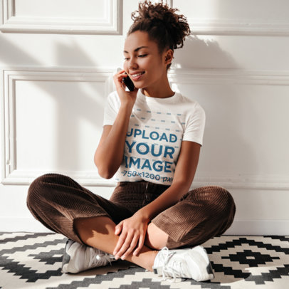 T-Shirt Mockup of a Woman Sitting on the Floor and Talking on Her Phone