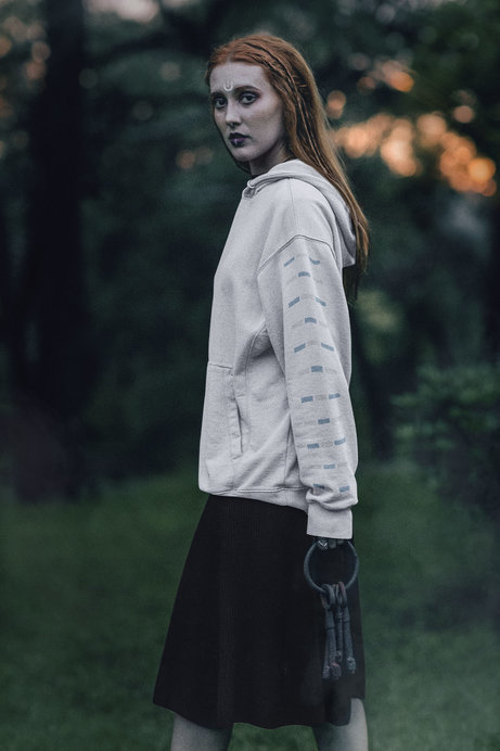 Mockup of a Witch Wearing a Hoodie in The Forest