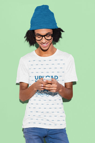 Round-Neck T-Shirt Mockup of a Teenager with Glasses Using His Smartphone