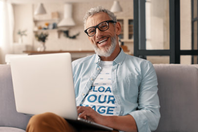 Heathered T-Shirt Mockup Featuring a Joyful Man Typing on a Laptop