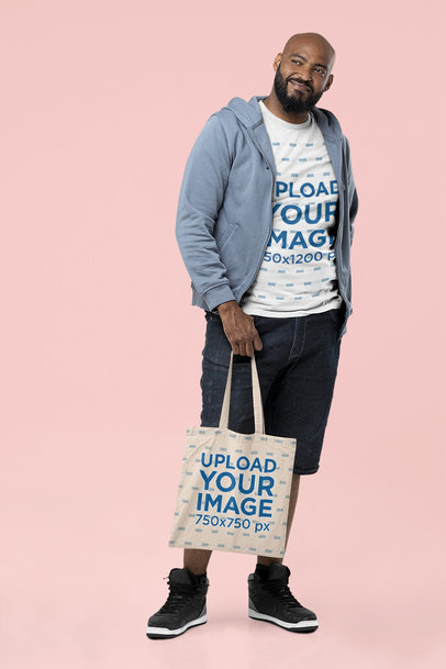 Mockup of a Tall Bold Man Holding a Tote Bag