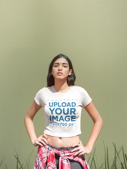 Latina Woman Wearing a Crop Top Tee Template Against a Solid Color Wall