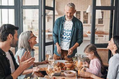 Heathered T-Shirt Mockup of a Man Hosting a Thanksgiving Family Dinner 