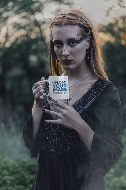 Mockup of a Woman with Dark Forest-Inspired Makeup Holding an 11 oz Mug