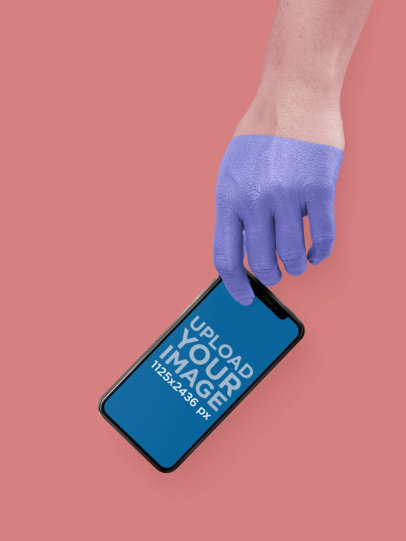 Black iPhone X Mockup Being Held by a Painted Hand a19309