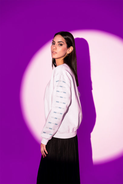 Sleeve Mockup of a Serious Woman Posing With a Hoodie in a Purple Light Studio