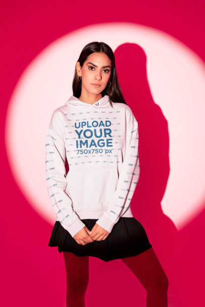 Pullover Hoodie Mockup Featuring a Serious Woman in a Studio With a Red Light