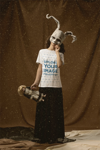 T-Shirt Mockup of a Kid Wearing a Creepy Bunny Mask and Holding a Vintage Doll