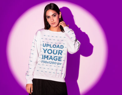 Sweatshirt Mockup Featuring a Serious Woman Posing Against a Purple Light