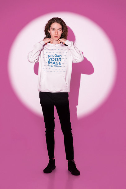 Pullover Hoodie Mockup Featuring a Man Posing by a Pink Light