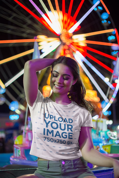 Beautiful Woman Posing Wearing a T-Shirt Mockup Near a Ferris Wheel