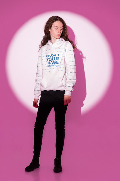 Pullover Hoodie Mockup Featuring a Serious Man Posing at a Studio With a Pink Lighting