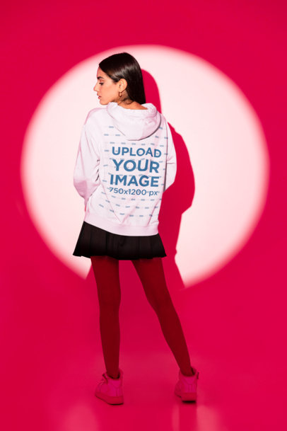 Back-View Hoodie Mockup Featuring a Woman Posing in a Spotlight
