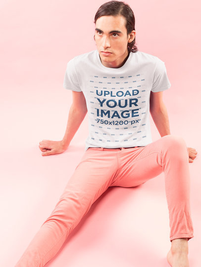 Dude Wearing a Tshirt Mockup Sitting on a Pink Floor