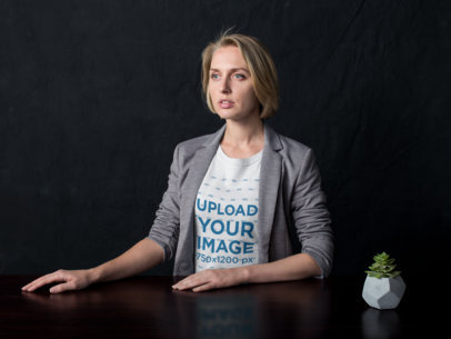 Blonde Woman Wearing a Tshirt Mockup Sitting on a Table with a Plant