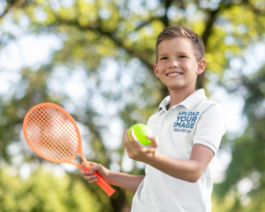 Polo Shirt Mockup of a Smiling Kid with a Tennis Ball and a Racket