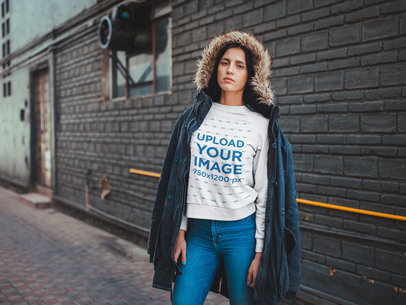 Woman Wearing a Crewneck Sweatshirt Mockup Outside a Warehouse During Winter