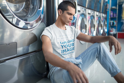 Man Wearing a T-Shirt Mockup and Jeans at a Laundry