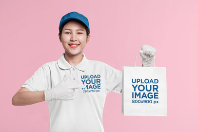 Polo Shirt Mockup of a Smiling Woman Pointing at a Paper Bag