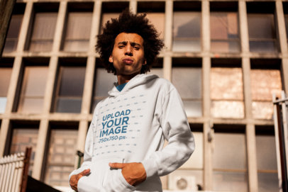 Man Wearing a Pullover Hoodie Afro Mockup while Outside an Abandoned Building