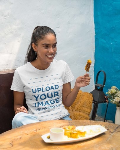 Gildan T-Shirt Mockup Featuring a Smiling Woman Eating Street Indian Food