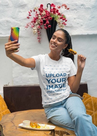 Gildan T-Shirt Mockup of a Happy Woman Taking a Selfie and Eating Indian Food