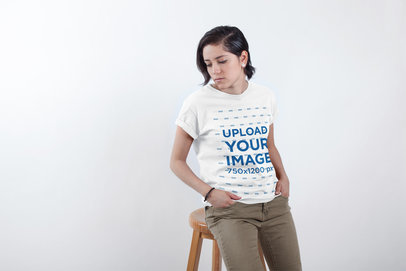 T-Shirt Mockup of a Woman Standing in a White Room