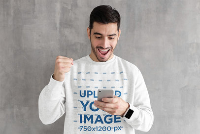 Heathered Sweatshirt Mockup of an Exciting Man Holding a Phone