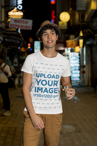 Gildan T-Shirt Mockup of a Man Walking with a Drink on a Street
