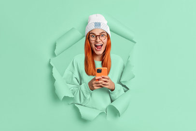 Beanie Mockup of an Excited Woman Posing Through a Torn Paper Hole