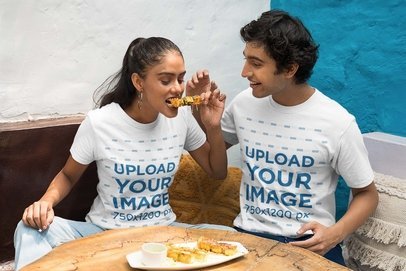 Gildan T-Shirt Mockup Featuring a Couple Eating Street Food