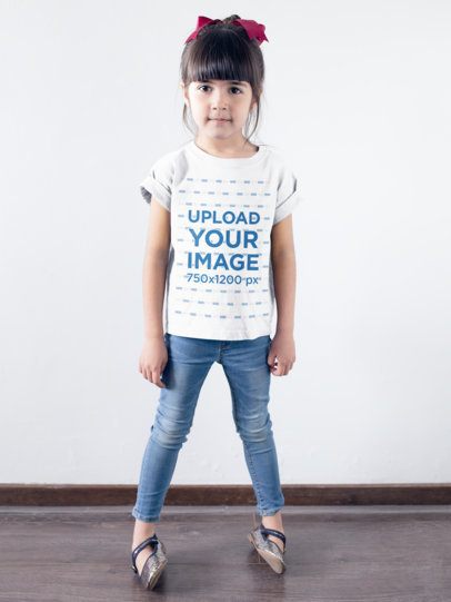 Little Girl Wearing a T-Shirt Mockup Against a White Wall