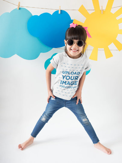 Happy Girl Wearing a T-Shirt Mockup and Round Sunglasses Under Sky Decorations
