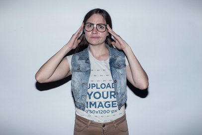 Nerd Woman with Glasses Wearing a T-Shirt Mockup and a Denim Vest