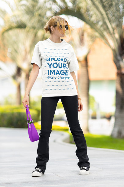 Round-Neck T-Shirt Mockup of a Woman With Sunglasses Carrying a Purse