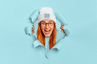 Beanie Mockup of a Happy Woman Posing Through a Torn Paper Hole