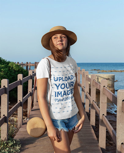 T-Shirt Mockup Featuring a Teenage Girl Posing by a Wooden Dock