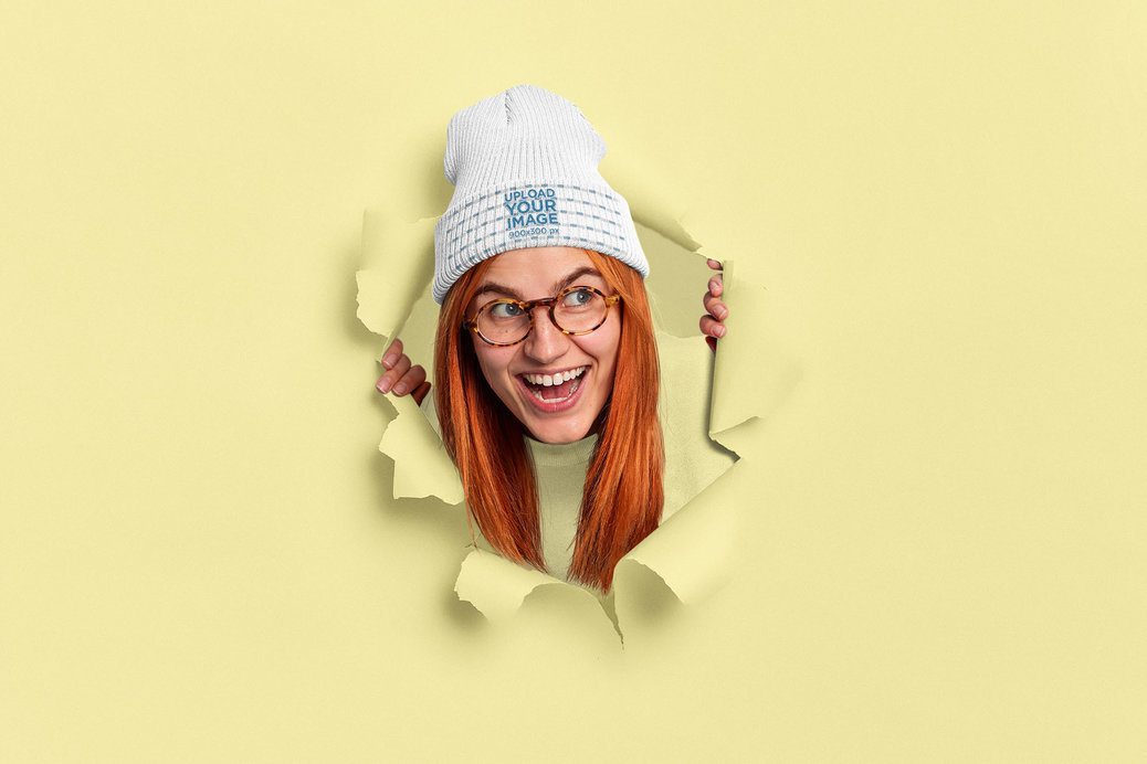Beanie Mockup Featuring a Cheerful Woman Coming Through a Torn Paper Hole