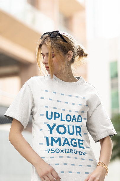 T-Shirt Mockup of a Woman With Sunglasses on Her Head Posing in the Street