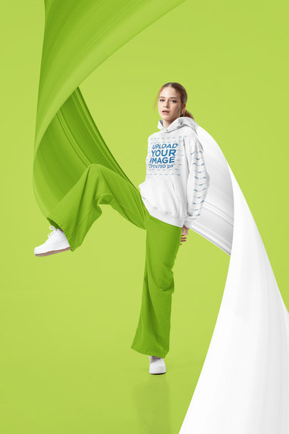 Mockup of a Woman Wearing a Pullover Hoodie with Customizable Sleeves at a Studio