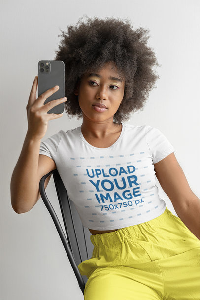 Bella Canvas Tee Mockup of a Woman with an Afro Hairstyle Taking a Mirror Selfie