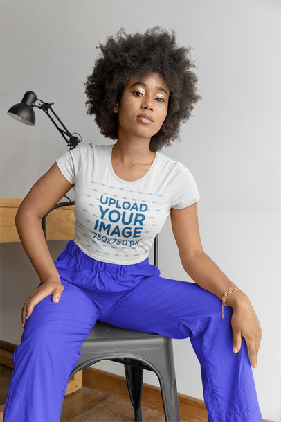 Bella Canvas Crop Top Mockup of a Woman With an Afro Hairstyle Posing in a Chair